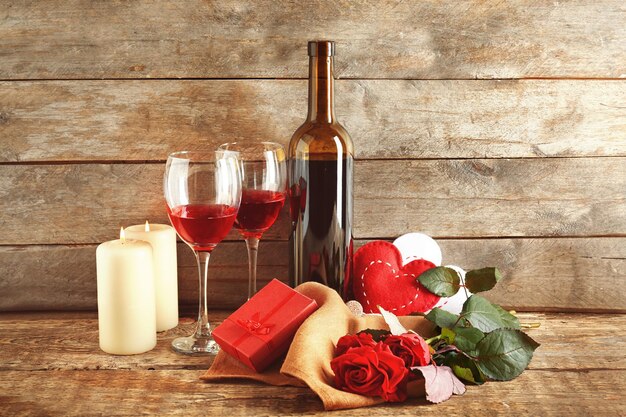 Concepto del día de San Valentín Composición de velas de rosas de vino y caja de regalo en la mesa de madera