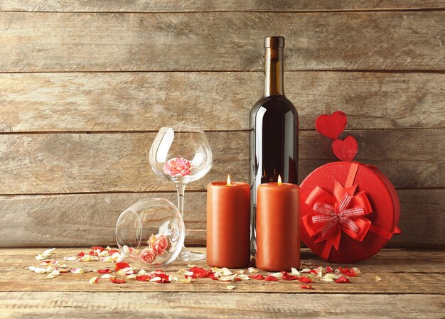 Concepto del día de San Valentín Composición de velas de rosas de vino y caja de regalo en la mesa de madera