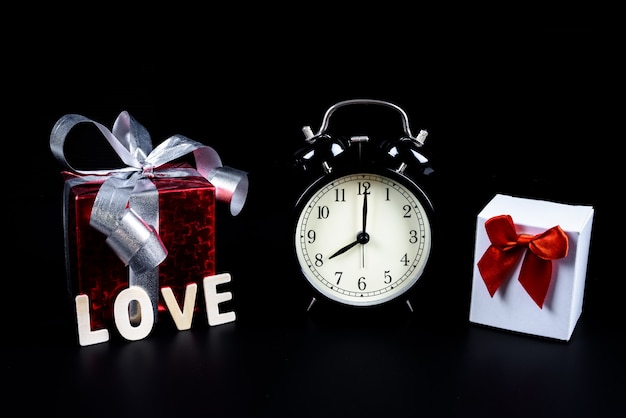 Concepto del día de San Valentín Despertador con caja de regalo y letras de madera palabra