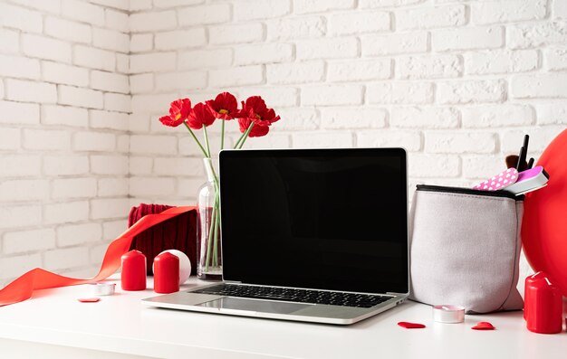 Foto concepto de día de san valentín y día de la mujer. portátil con accesorios cosméticos y spa, caja de regalo