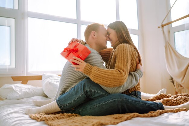 Concepto del Día de San Valentín Intercambio de regalos Pareja joven en casa celebrando el Día de San Valentín