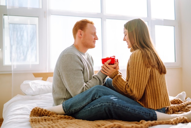 Concepto del Día de San Valentín Intercambio de regalos Pareja joven en casa celebrando el Día de San Valentín