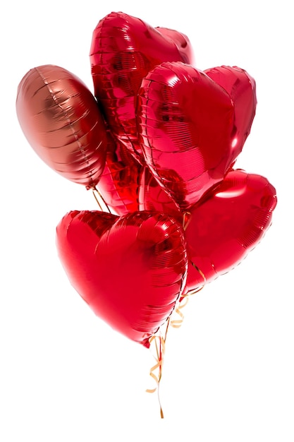 Foto el concepto del día de san valentín: un montón de globos de aluminio con forma de corazón rojo aislados en fondo blanco