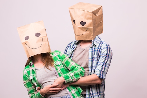 Concepto del día de San Valentín - Pareja de amor joven con bolsas sobre la cabeza sobre fondo blanco.