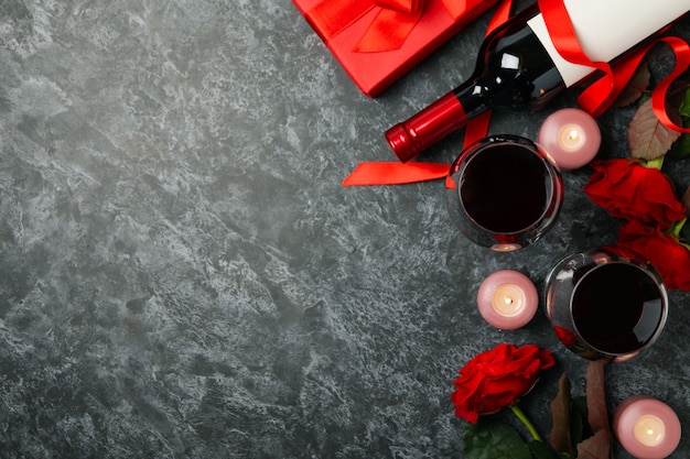 Foto concepto del día de san valentín con rosas y vino en la mesa ahumada negra