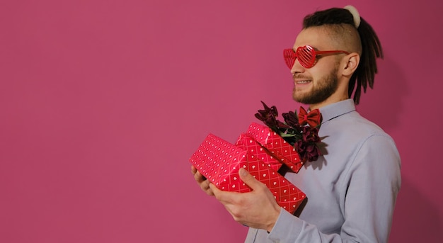 Concepto del día de San Valentín El tipo usa anteojos en forma de corazón y pajarita