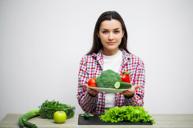 Concepto de dieta y alimentación saludable mujer con verduras sobre fondo de pared blanca