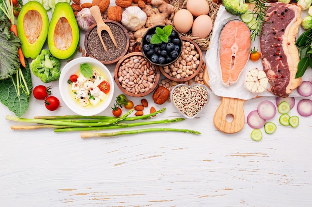 Concepto de dieta cetogénica baja en carbohidratos. ingredientes para la selección de alimentos saludables sobre fondo blanco de madera.