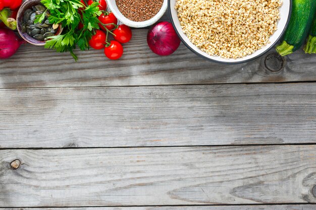 Concepto de dieta y comida sana. Alforfón verde, semillas de girasol y lino, verduras y verduras vista superior sobre fondo blanco de madera con espacio de copia