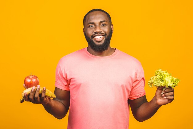 Concepto de dieta. Hombre negro afroamericano sano que sostiene las frutas.