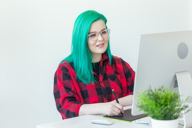 Concepto de diseñador gráfico, animador e ilustrador. mujer joven con cabello verde trabajando en el