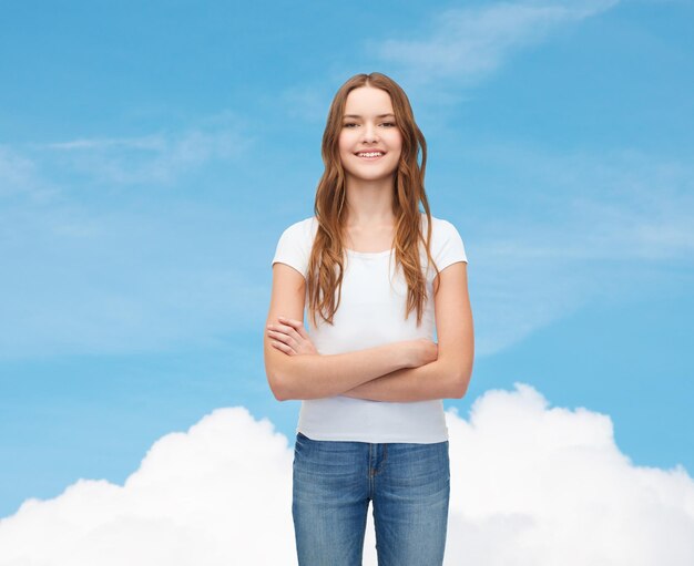 Foto concepto de diseño de camisetas: adolescente sonriente con una camiseta blanca en blanco con los brazos cruzados