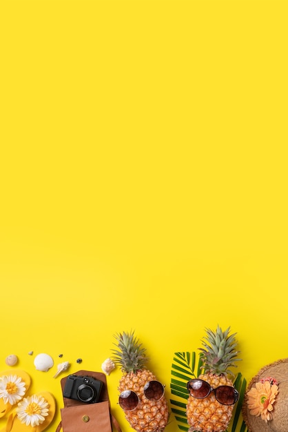 Concepto de diseño de fondo de frutas de verano. Vista superior de la playa de viajes de vacaciones con conchas, piña y hojas de palmera sobre fondo amarillo.