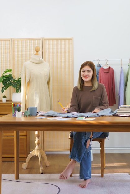 Concepto de diseño de moda Diseñador de moda midiendo el tamaño de la camisa y tomando notas en el cuaderno