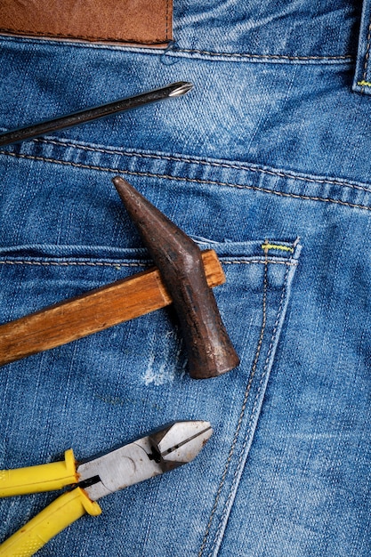 Concepto de diseño de vista superior del Día del Trabajo con herramientas de trabajo sobre fondo de blue jeans.