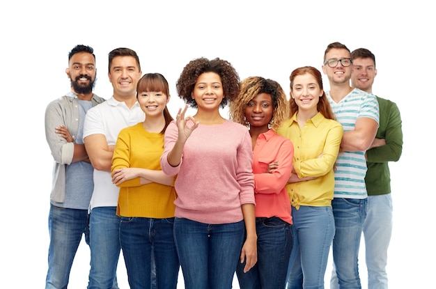 Foto concepto de diversidad, raza, etnia y personas - grupo internacional de hombres y mujeres sonrientes felices mostrando el signo de la mano ok sobre blanco