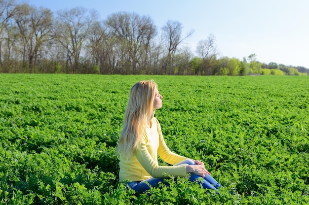 Concepto de diversión al aire libre. Mujer joven descansando sobre la hierba verde en la pradera