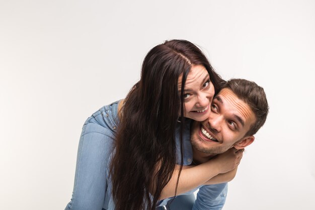 Concepto de diversión y relación: hombre con novia en la espalda sobre fondo blanco.