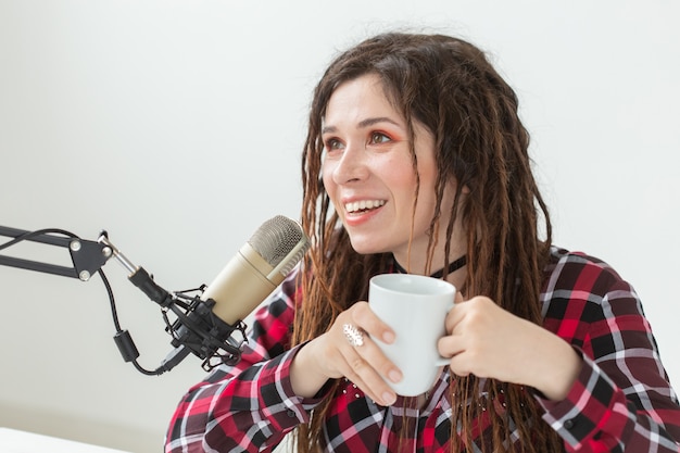 Concepto de DJ, presentador de radio y blogs - mujer joven que trabaja en el estudio.