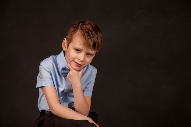 Concepto de duda, alerta y consideración, déjame pensar. Retrato de niño en edad preescolar con expresión perpleja y seria en la cara, el niño con la mano en la barbilla piensa, duda, elección correcta. Copia espacio