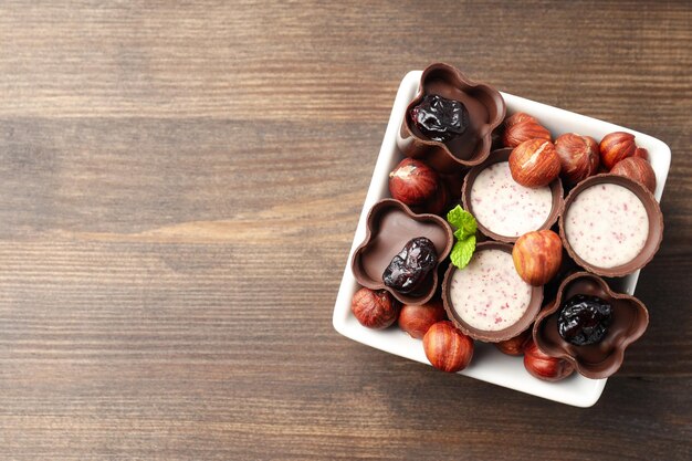 Concepto de dulces con caramelos de chocolate sobre fondo de madera