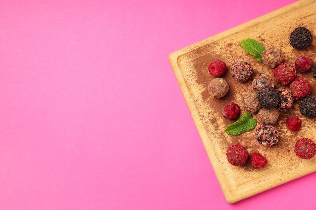 Concepto de dulces con caramelos de chocolate sobre fondo rosa