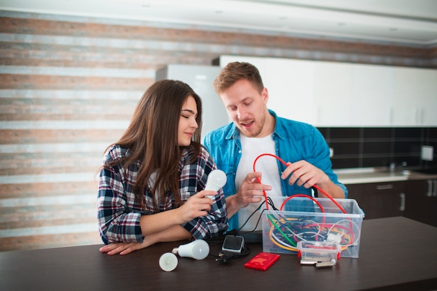 Foto concepto de eco. protección del medio ambiente. la familia está clasificando los viejos aparatos eléctricos domésticos. el vidrio, las bombillas, el hierro, el caucho, el metal, las baterías y los cables deben reciclarse. proteger responsablemente la naturaleza