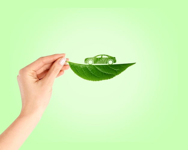 Foto el concepto de ecología de la hoja verde en la mano con el coche verde