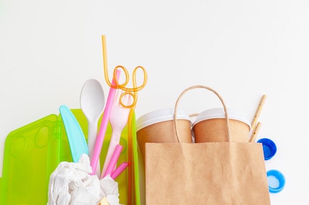 Concepto de ecología de peligro de residuos plásticos con basura y coloridas pajitas de un solo uso, tazas de cubiertos, botellas