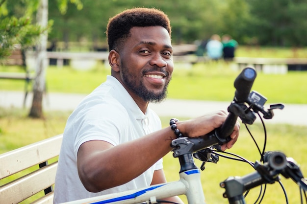 Concepto de ecología y transporte moderno joven empresario afroamericano en bicicleta para trabajar en bicicleta