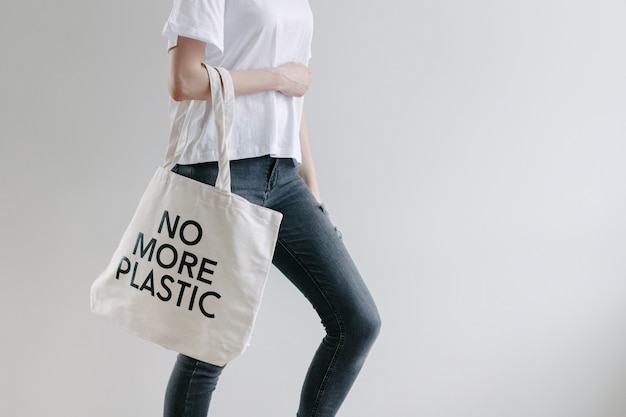 Concepto ecológico de mujer sosteniendo bolsa ecológica textil blanca