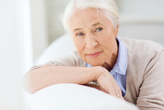 concepto de edad y personas - cara de mujer senior sonriente feliz en casa