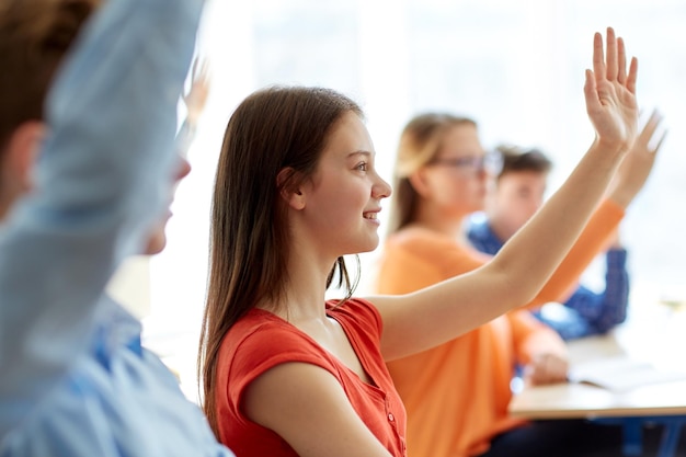 concepto de educación, aprendizaje y personas - grupo de estudiantes con libros y cuadernos en la lección escolar