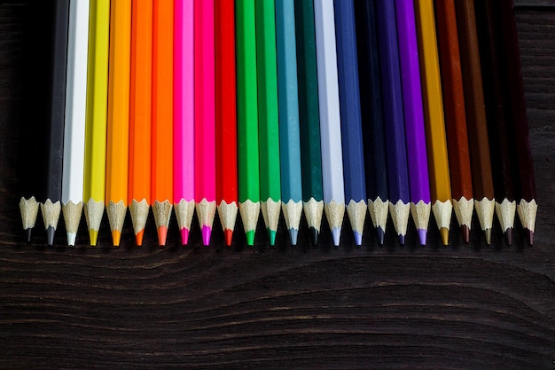 Concepto de educación y creatividad lápices de colores sobre fondo de madera