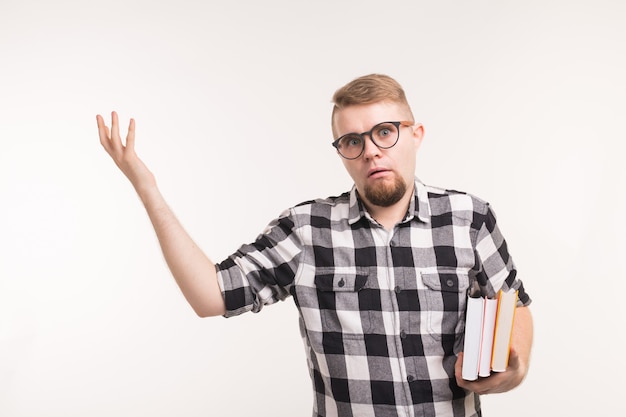 Concepto de educación, emociones, friki y nerd: el hombre con gafas y libros parece perplejo.