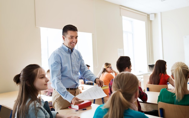 concepto de educación, escuela, aprendizaje y personas - grupo de estudiantes y profesores con resultados de pruebas en el aula