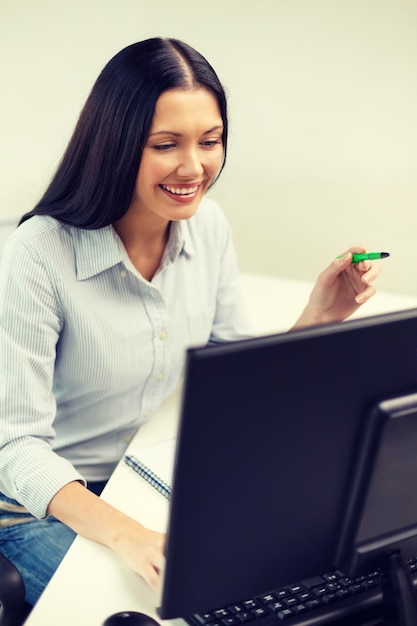 concepto de educación, escuela, negocios y tecnología - empresaria sonriente o estudiante estudiando