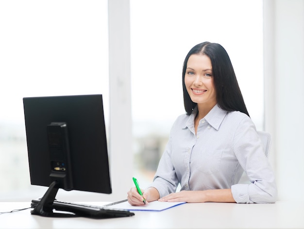 concepto de educación, escuela, negocios y tecnología - empresaria sonriente o estudiante estudiando