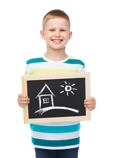 concepto de educación, escuela y publicidad - niño pequeño sonriente sosteniendo pizarra negra con dibujo casero