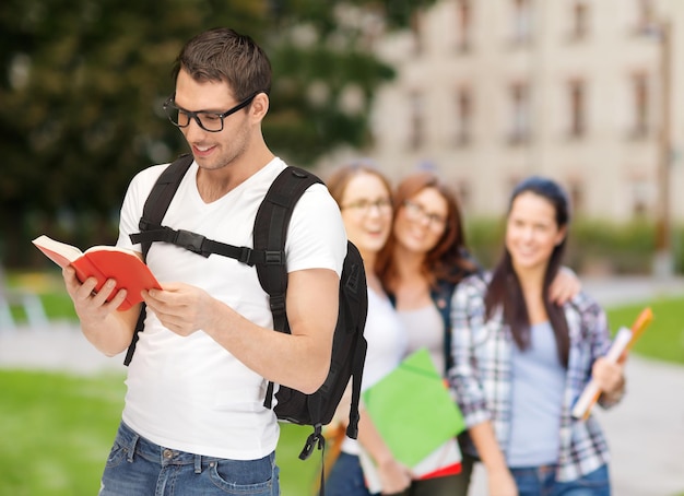 concepto de educación, escuela y vacaciones - estudiante viajero con anteojos con mochila y libro