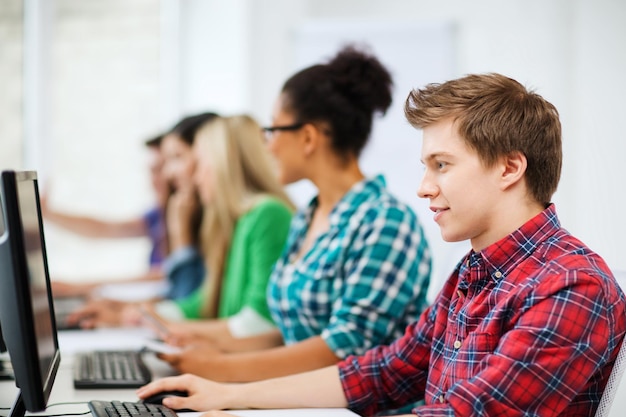 Concepto de educación - estudiante con computadora estudiando en la escuela