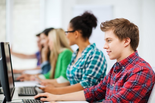 concepto de educación - estudiante con computadora estudiando en la escuela