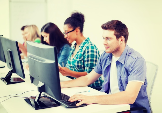 Concepto de educación - estudiante con computadora estudiando en la escuela
