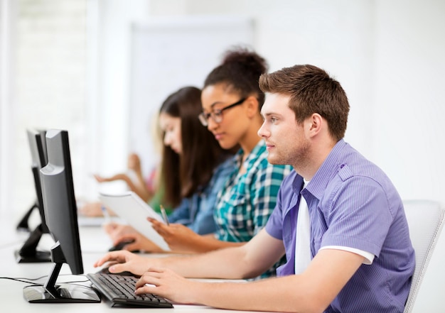 concepto de educación - estudiante con computadoras que estudian en la escuela