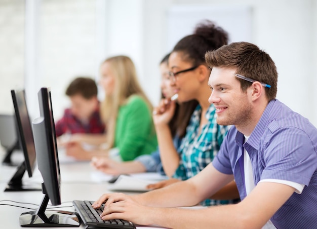 concepto de educación - estudiante con computadoras que estudian en la escuela