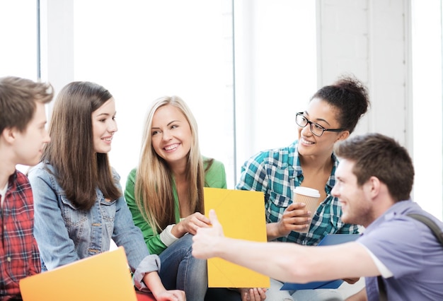 concepto de educación - estudiantes comunicándose y riéndose de la escuela