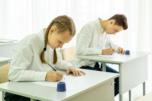 El concepto de educación y formación de personas es un grupo de estudiantes que escriben una prueba escolar en su