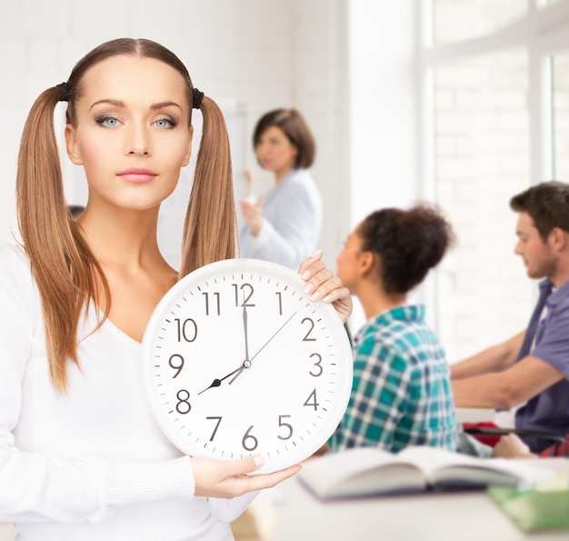 Concepto de educación y gestión del tiempo - estudiante atractivo que muestra el reloj