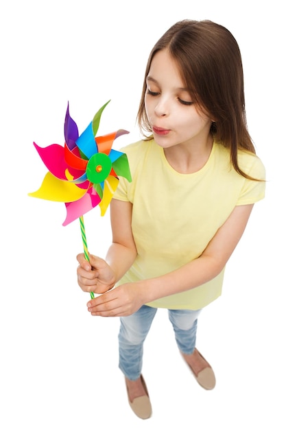 concepto de educación, infancia y ecología - niño sonriente con colorido juguete de molino de viento