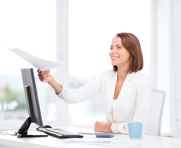 concepto de educación y negocios - mujer de negocios sonriente dando papeles en la oficina